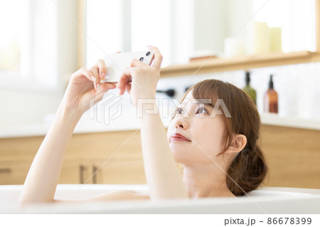 お風呂でスマートフォンを使う女性 お風呂でスマートフォンを使う女性 86678399