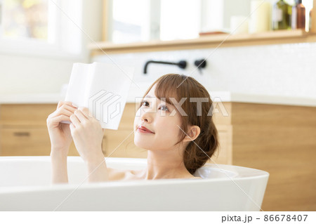 お風呂に浸かりながら読書を楽しむ女性 86678407