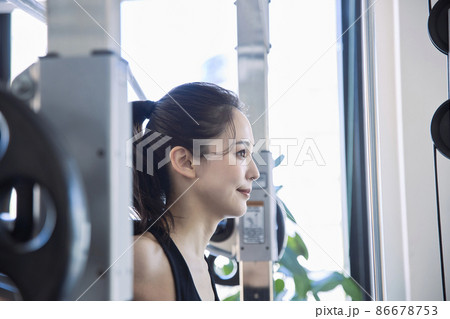 スポーツジムでトレーニングをする若い女性 86678753