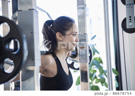 スポーツジムでトレーニングをする若い女性 スポーツジムでトレーニングをする若い女性 86678754