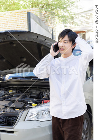 自動車の故障で保険会社に電話をする男性 自動車の故障で保険会社に電話をする男性 86679104
