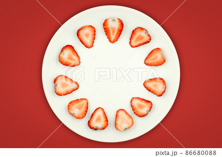 Top view of half strawberry in a plate on isolated red background. Top view of half strawberry in a plate on isolated red background. 86680088