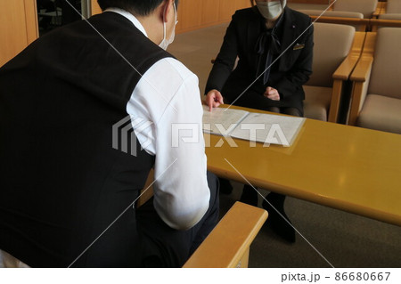 喪主と打ち合わせをするセレモニーレディー 喪主と打ち合わせをするセレモニーレディー 86680667