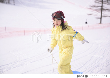 スキー場のゲレンデで雪遊びする小学生の女の子 スキー場のゲレンデで雪遊びする小学生の女の子 86680871