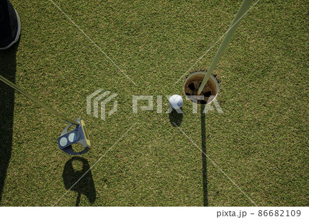Golfer practice training putting golf ball on the green, lens flare on sun set evening time 86682109