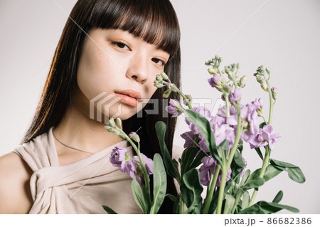 花を持つ20代女性のナチュラルビューティイメージ 86682386