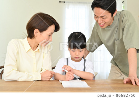 両親に見守られて学習する女の子 86682750