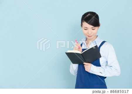 手帳を書くエプロンの女性 手帳を書くエプロンの女性 86685017