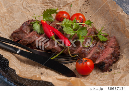 beef steak on parchment decorated with pepper and herbs 86687134