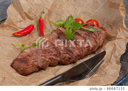 beef steak on parchment decorated with pepper and herbs 86687135