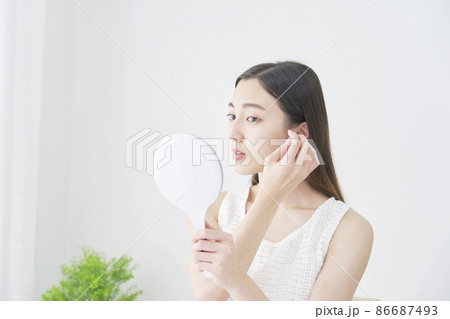 鏡で髪の毛を見る女性 86687493