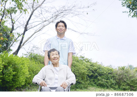 介護士と車椅子に乗る高齢者 屋外 介護士と車椅子に乗る高齢者 屋外 86687506