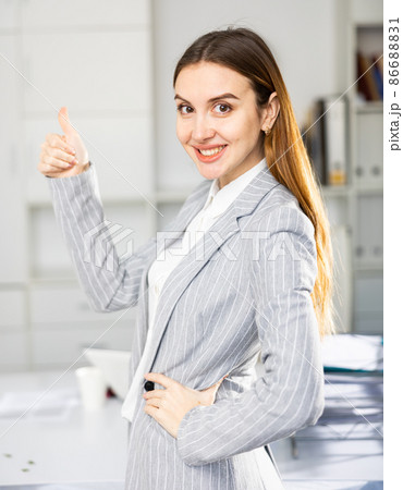 Woman office worker making thumb up gesture Woman office worker making thumb up gesture 86688831