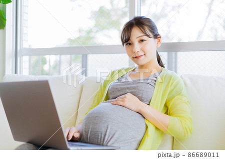 ソファでパソコンを使う妊婦さん 86689011
