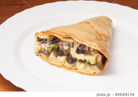 crepe with potatoes and mushrooms on a white plate crepe with potatoes and mushrooms on a white plate 86689236