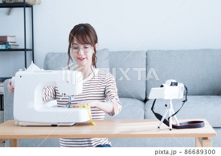 ミシンで裁縫をしながら動画を撮影する女性 ミシンで裁縫をしながら動画を撮影する女性 86689300