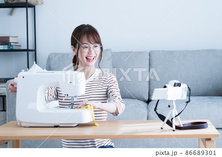ミシンで裁縫をしながら動画を撮影する女性 ミシンで裁縫をしながら動画を撮影する女性 86689301