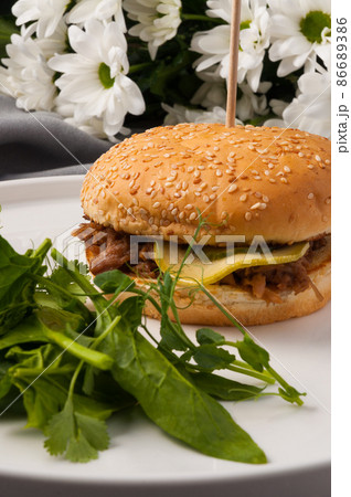 Burger with boiled beef, zucchini and pickle. Vertical frame 86689386