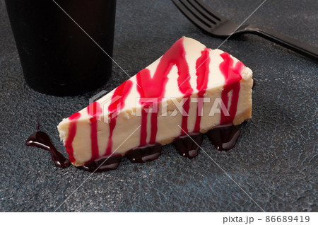 cheesecake with berry sauce on a dark background 86689419