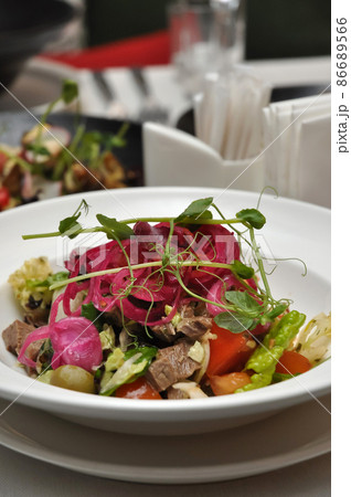 salad with vegetables and boiled beef on a white plate in a restaurant 86689566