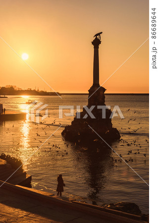 Sunset on embankment of Sevastopol. Monument to sunken ships against the sun. Sevastopol, Crimea Sunset on embankment of Sevastopol. Monument to sunken ships against the sun. Sevastopol, Crimea 86689644