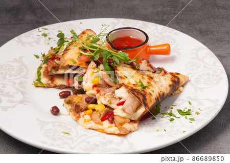 bright and juicy Mexican quesadilla with hot sauce 86689850