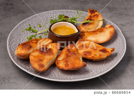 small pies with meat and mustard sauce 86689854