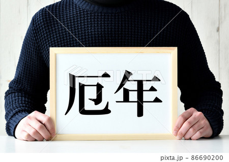 厄年と書かれたフレームを持つ男性 86690200