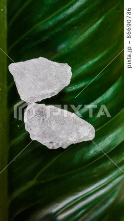 Crystal clear alum cubes or Potassium alum on green leaf. Chemical compound substance. Concept for beauty , spa and underarm treatment industrial. Crystal clear alum cubes or Potassium alum on green leaf. Chemical compound substance. Concept for beauty , spa and underarm treatment industrial. 86690786