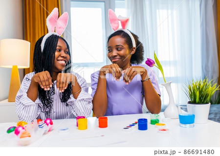 two polyethnic pretty woman having fun and preparing to easter together 86691480