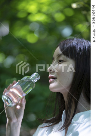 ミネラルウォーターを持つ女性 86693444