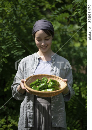 収穫野菜を持つ女性 86693470
