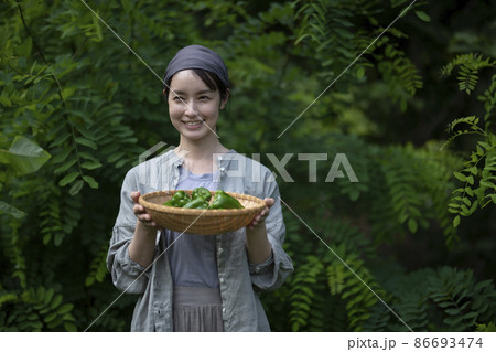 収穫野菜を持つ女性 86693474