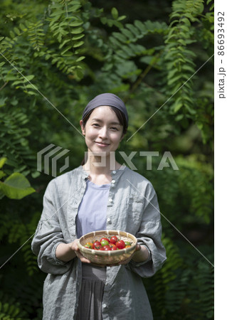 収穫野菜を持つ女性 86693492