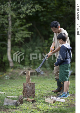父に薪割りを教わる子供 86693637