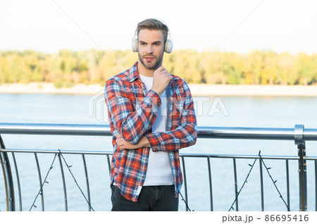education online. listening audio book. trendy handsome man in casual checkered shirt. 86695416