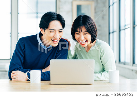 パソコンを見る若い夫婦　　 86695455