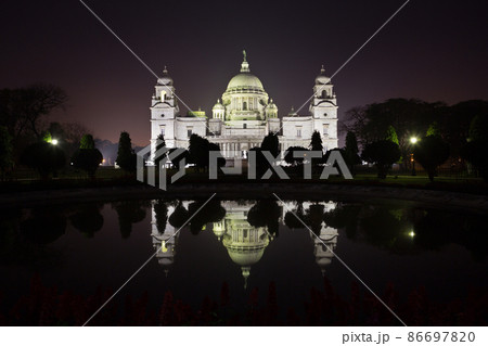 Illuminated memorial of Queen Victoria, against the backdrop of a black sky, in the night city of Kolkata 86697820