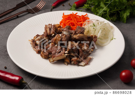 small pieces of lamb on the bone with onions and carrots small pieces of lamb on the bone with onions and carrots 86698028
