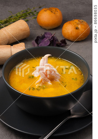 chicken soup with rolls in a dark bowl chicken soup with rolls in a dark bowl 86698035