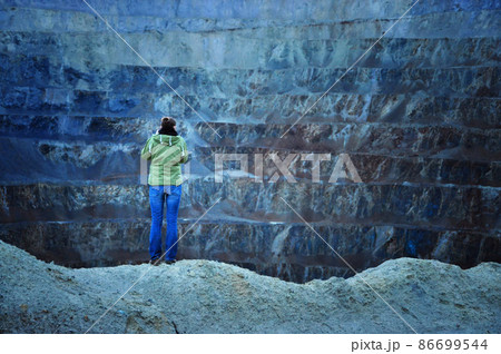 Geologist studying gigantic open cast gold and copper mine terraces. Romania Geologist studying gigantic open cast gold and copper mine terraces. Romania 86699544