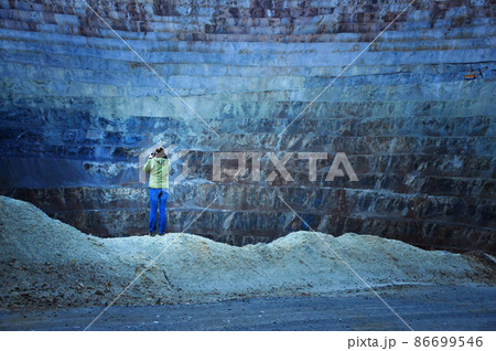 Geologist studying gigantic open cast gold and copper mine terraces. Romania 86699546