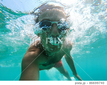 Underwater view of a diver man swimming Underwater view of a diver man swimming 86699740