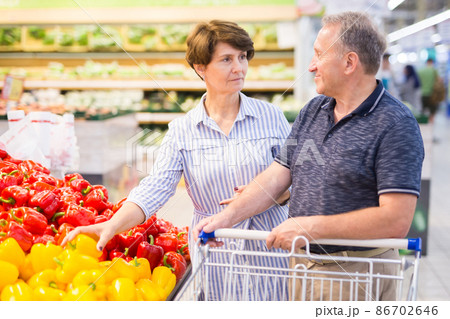 Elderly couple buys bell pepper in the alcoholic vegetables of a supermarket 86702646