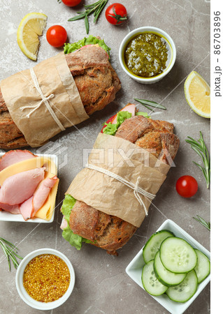 Concept of tasty eating with ciabatta sandwiches on gray textured table Concept of tasty eating with ciabatta sandwiches on gray textured table 86703896
