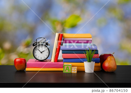 Stack of books on wooden table against blurred background Stack of books on wooden table against blurred background 86704150
