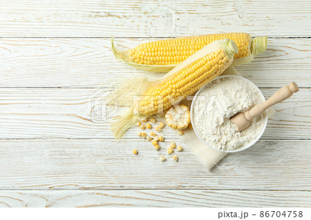 Raw corn and flour on white wooden table 86704758