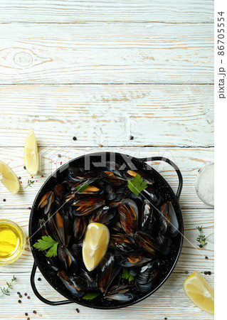 Concept of delicious food with mussels on white wooden table 86705554