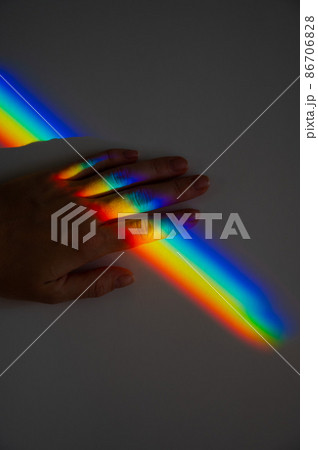 Rainbow ray on a woman's hand.  86706828