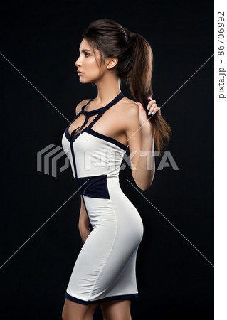 Sexy and stylish brunette woman in dress posing at 86706992